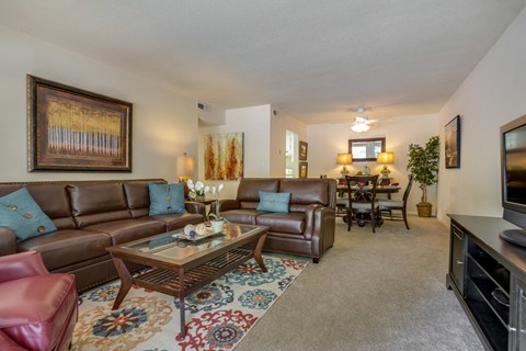 A living room with brown leather couches and a glass coffee table.