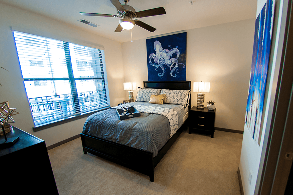 a bedroom with a bed and a ceiling fan