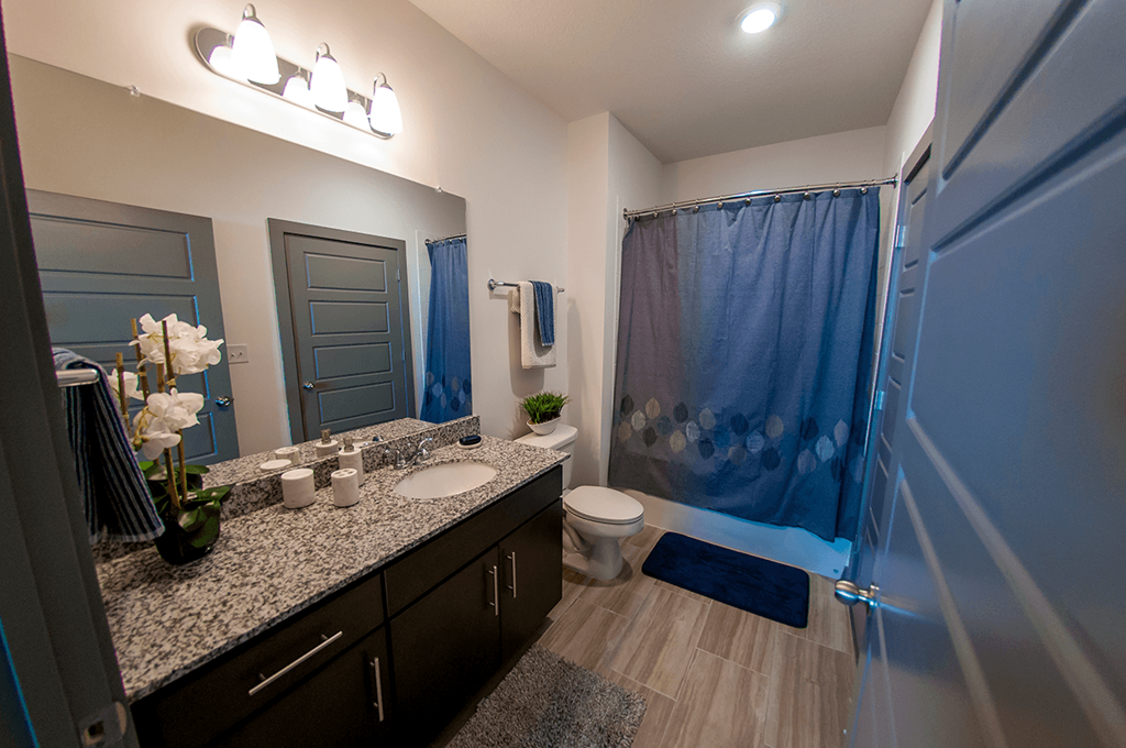 a bathroom with a shower and a sink and a toilet