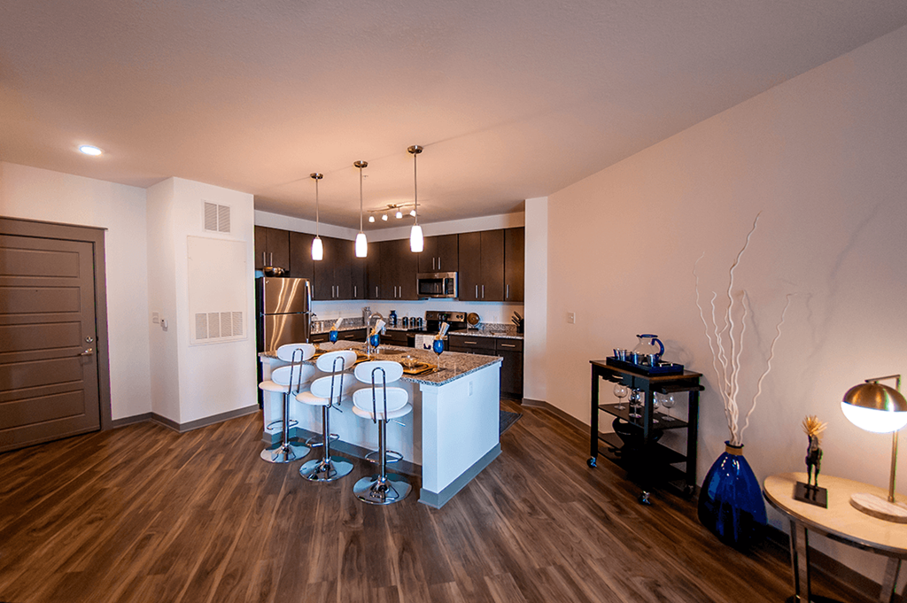 an open kitchen and dining room with a bar and stools
