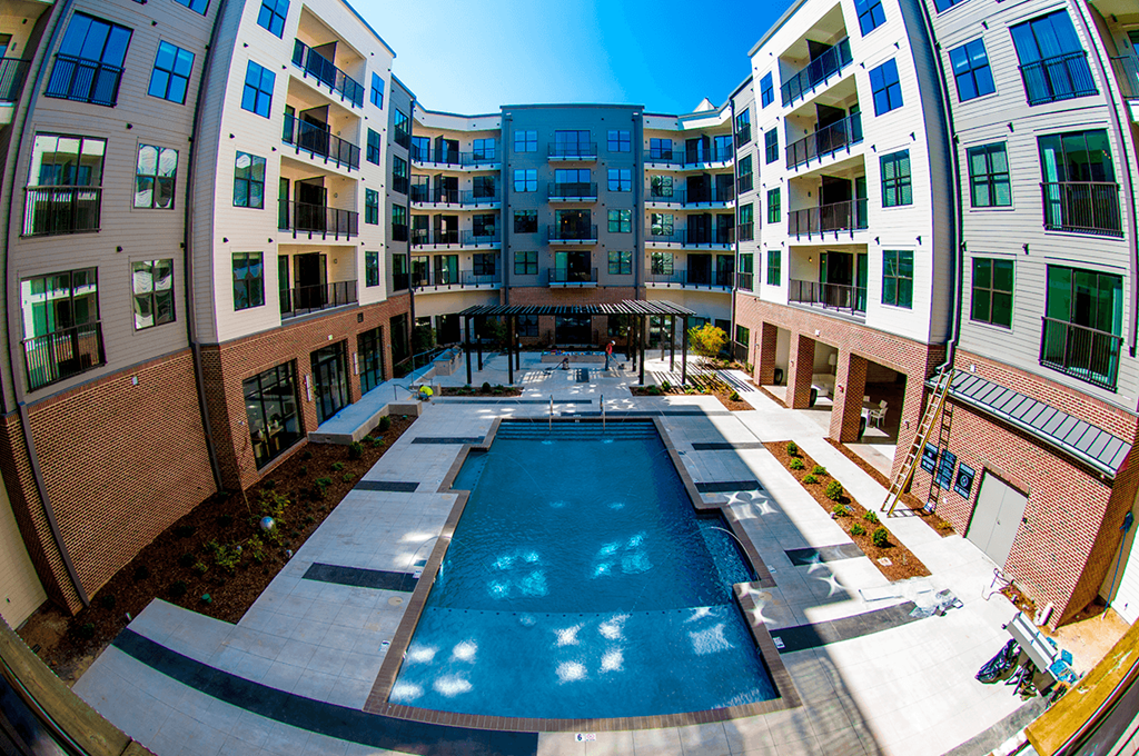 an apartment building with a pool in the middle of it