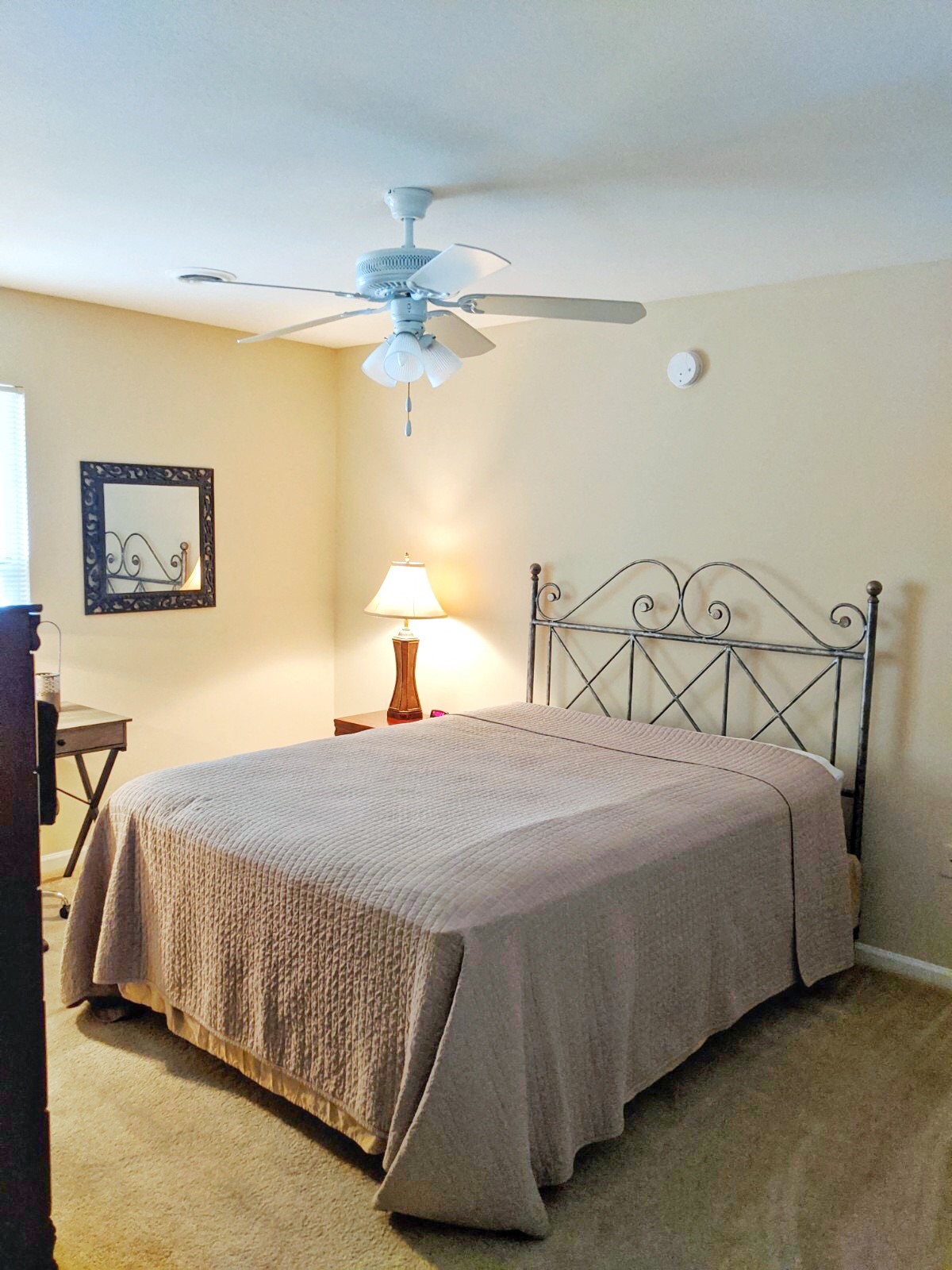 a bedroom with a bed and a ceiling fan