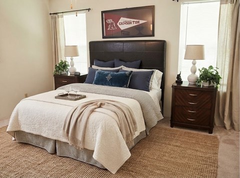 A bedroom with a large bed and a painting on the wall.