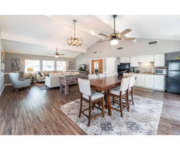 a kitchen and living room with a dining table and chairs