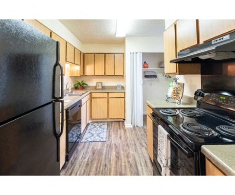 a kitchen with black appliances and wooden cabinets
