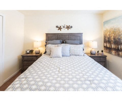 a bedroom with a bed and a painting on the wall
