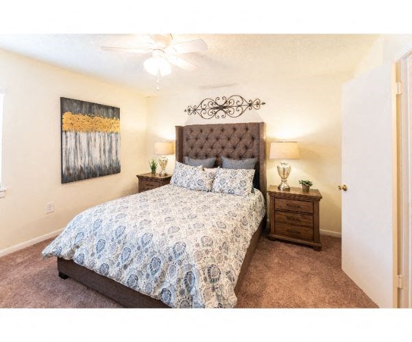 a bedroom with a bed and a ceiling fan