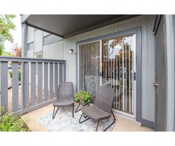 a patio with two chairs and a table on a balcony