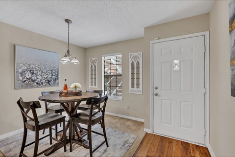 a dining room with a table and chairs and a white door