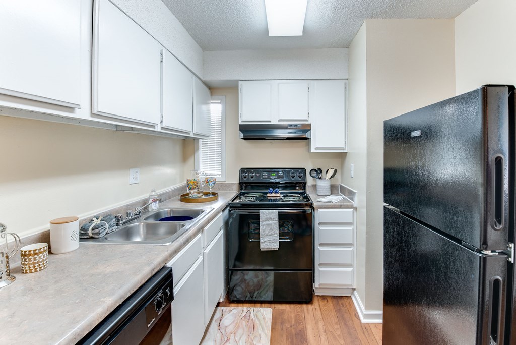 a kitchen with white cabinets and black appliances