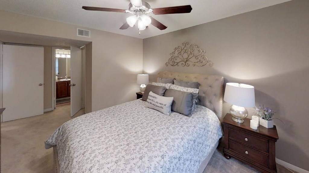 a bedroom with a bed and a ceiling fan