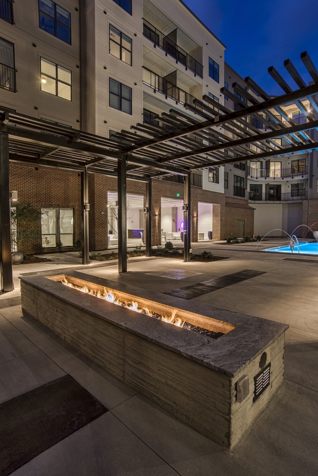 a fire pit in the middle of an apartment complex at night