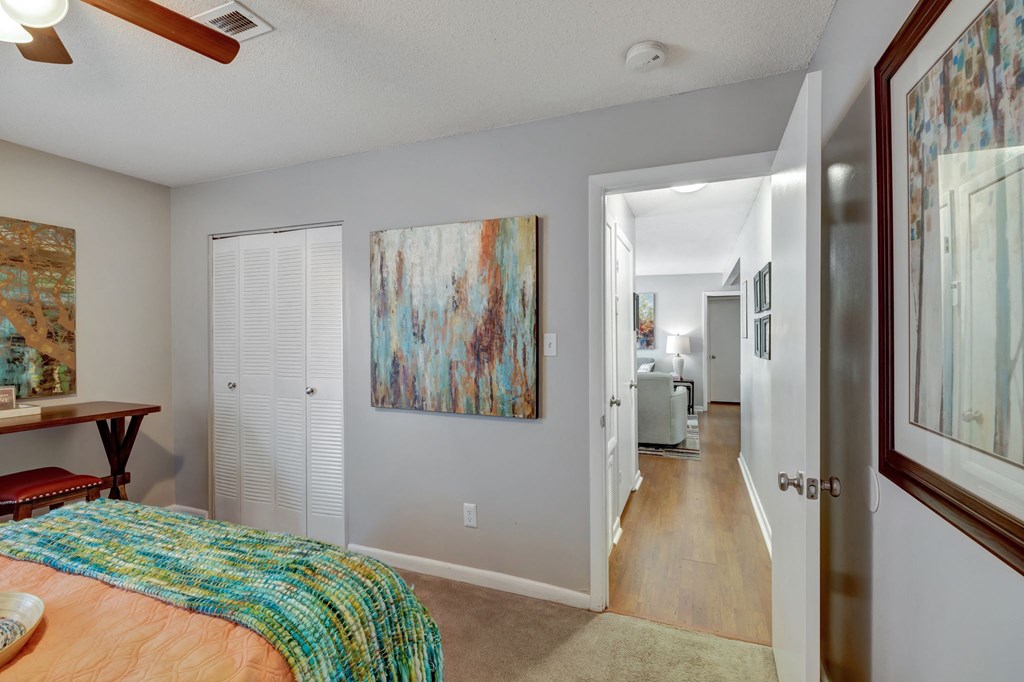 a bedroom with a bed and a hallway to a living room