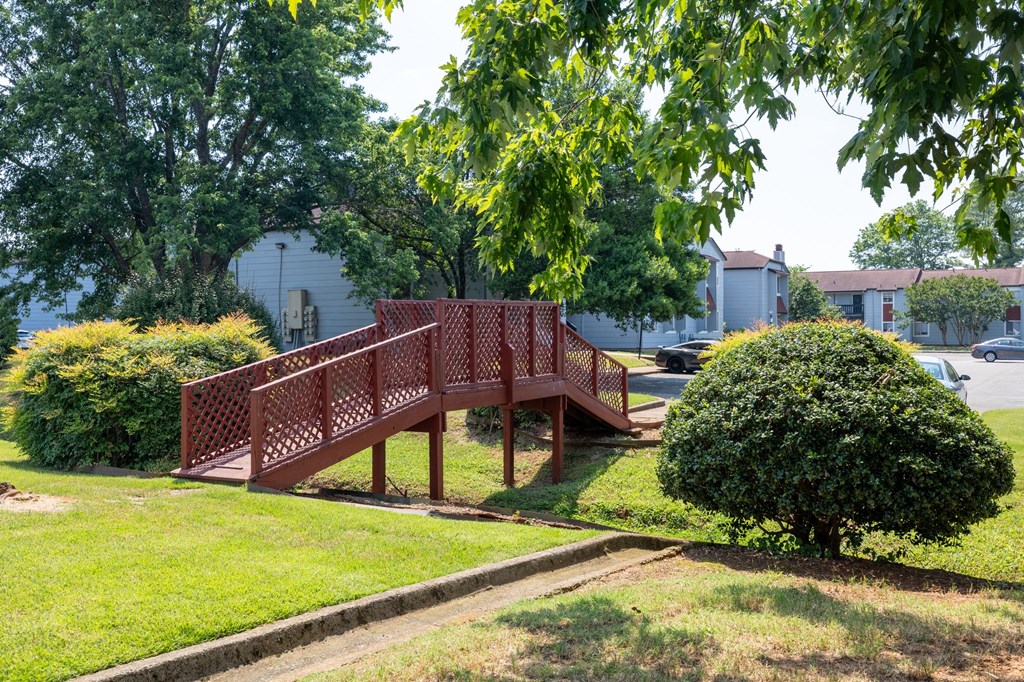 a wooden bridge in the middle of a park