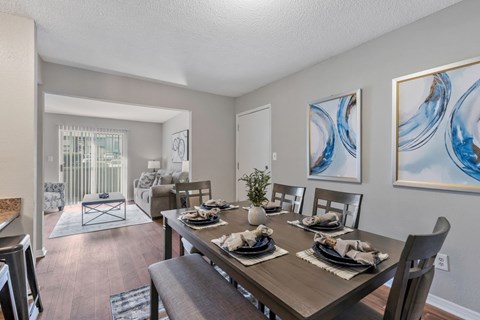 A dining room with a wooden table set for a meal.