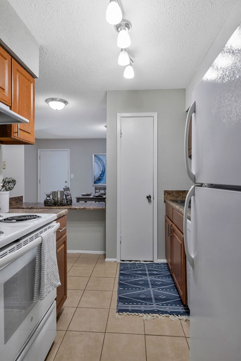 A kitchen with a white stove top oven and a white refrigerator.