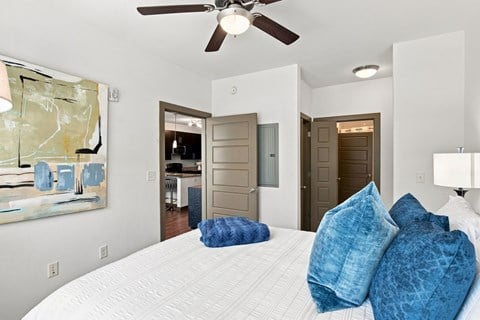 A bedroom with a large bed and a ceiling fan.