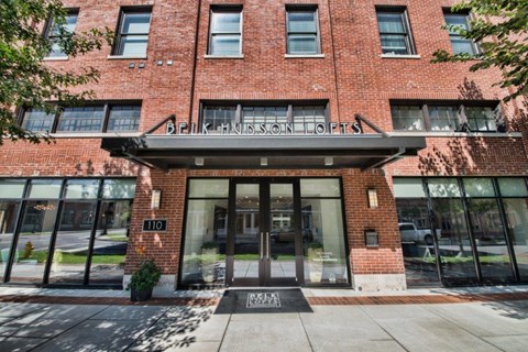 the front of a red brick building with glass doors