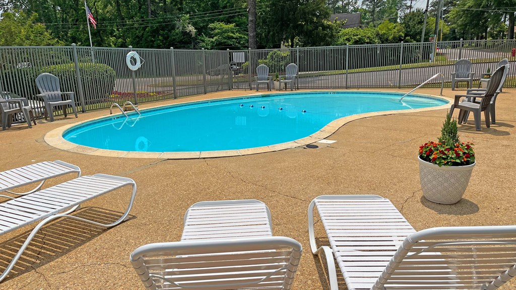 a swimming pool with chairs and chairs around it