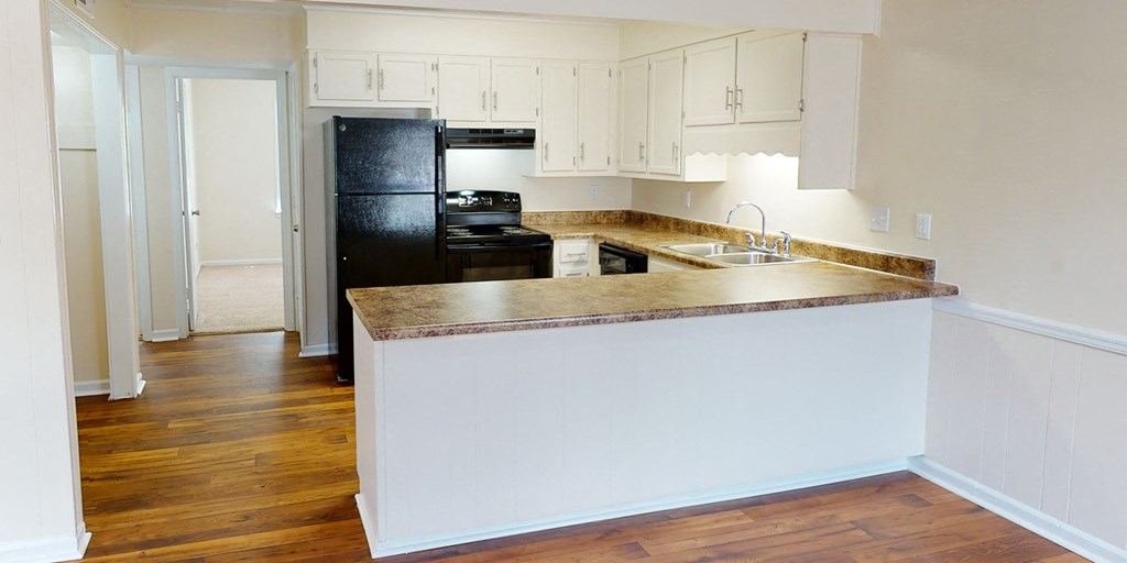 a kitchen with an island and a black refrigerator