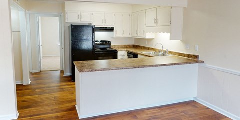 a kitchen with an island and a black refrigerator