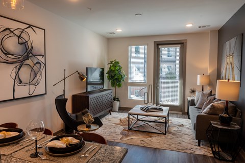 A modern living room with a dining table set for two.