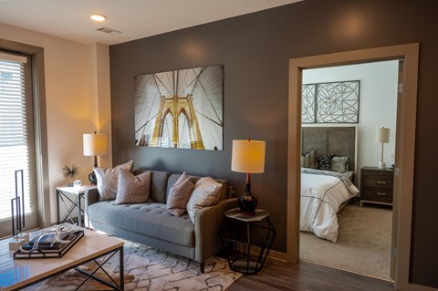 A living room with a grey couch, a coffee table, and two lamps.