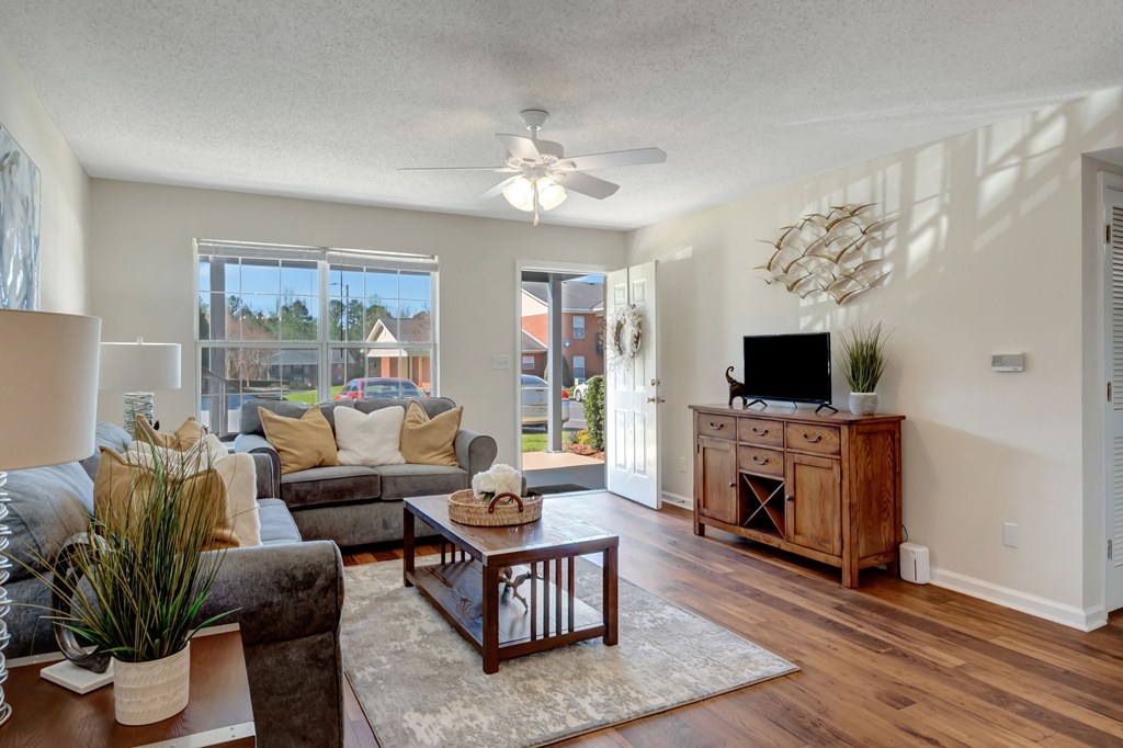 A living room with a grey couch and a wooden coffee table.