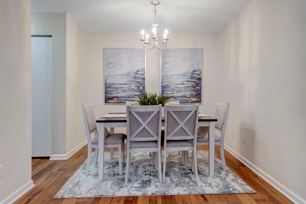 A dining room with a table set for four.