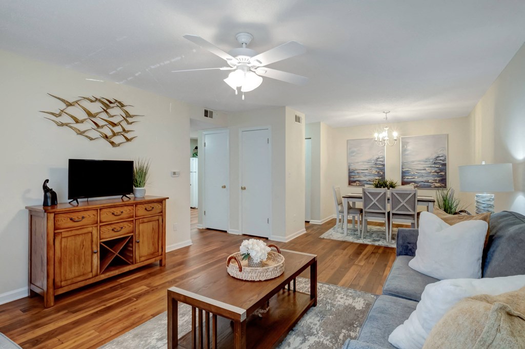 A living room with a wooden cabinet and a flat screen TV on top of it.