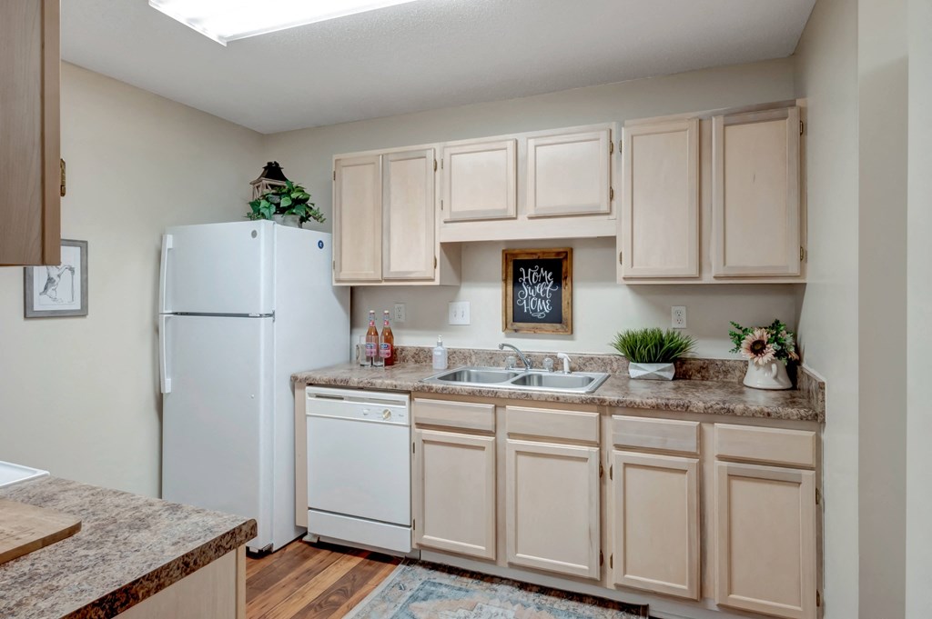 A kitchen with a white refrigerator and cabinets.