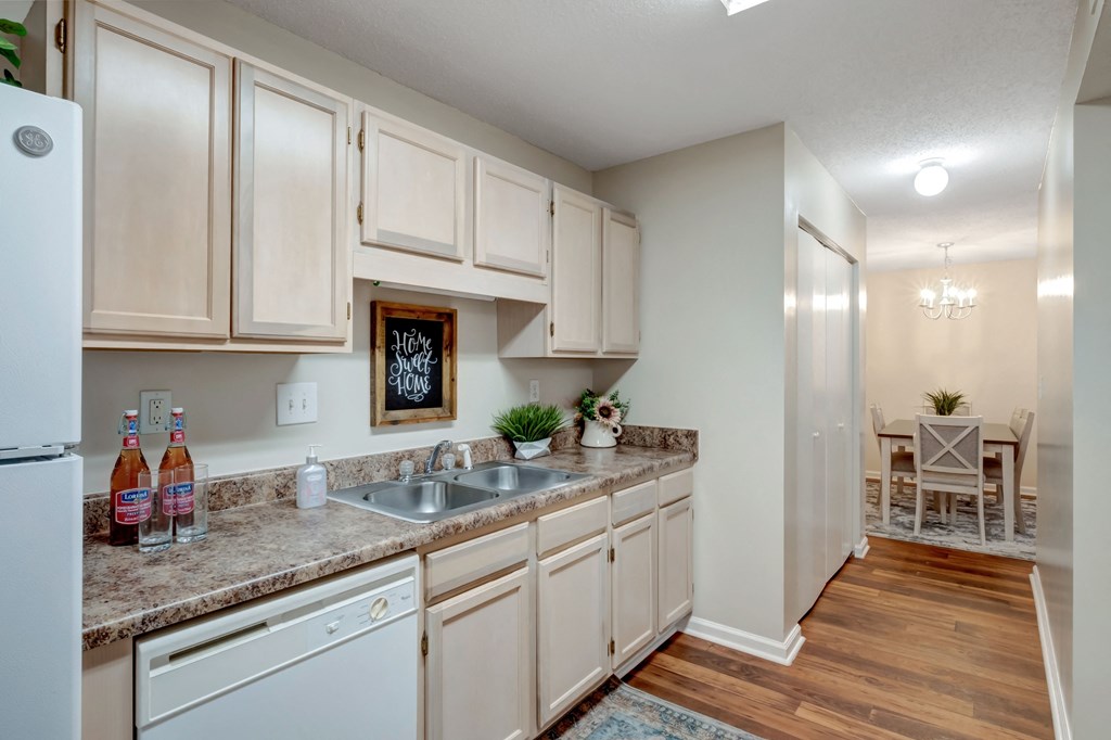 A kitchen with wooden cabinets and a white fridge.