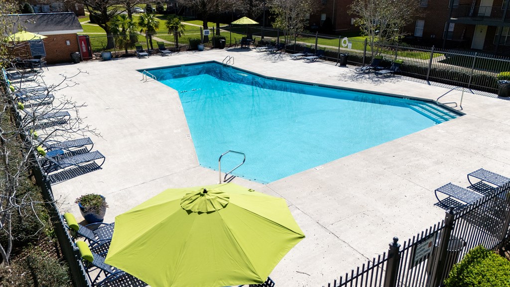 A pool with a yellow umbrella in the foreground.