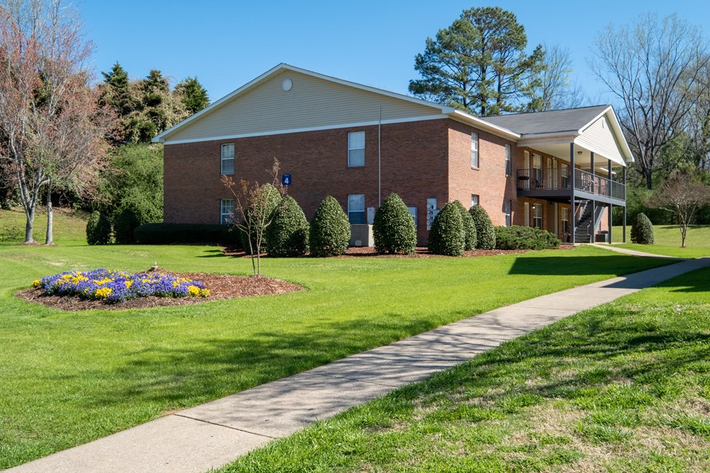 A brick house with a flower bed in front.