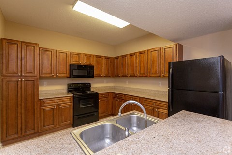 a kitchen with black appliances and wooden cabinets