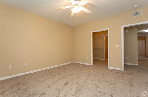 the spacious living room with carpet and a ceiling fan