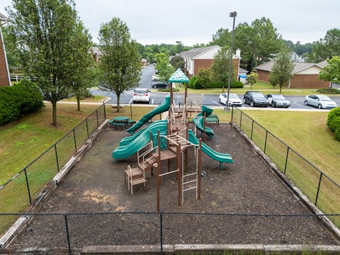 a playground with slides and chairs in a park