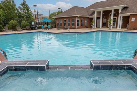 a large swimming pool with a building and a resort style pool
