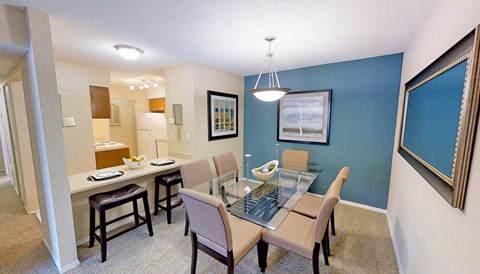 A dining room with a glass table and chairs.