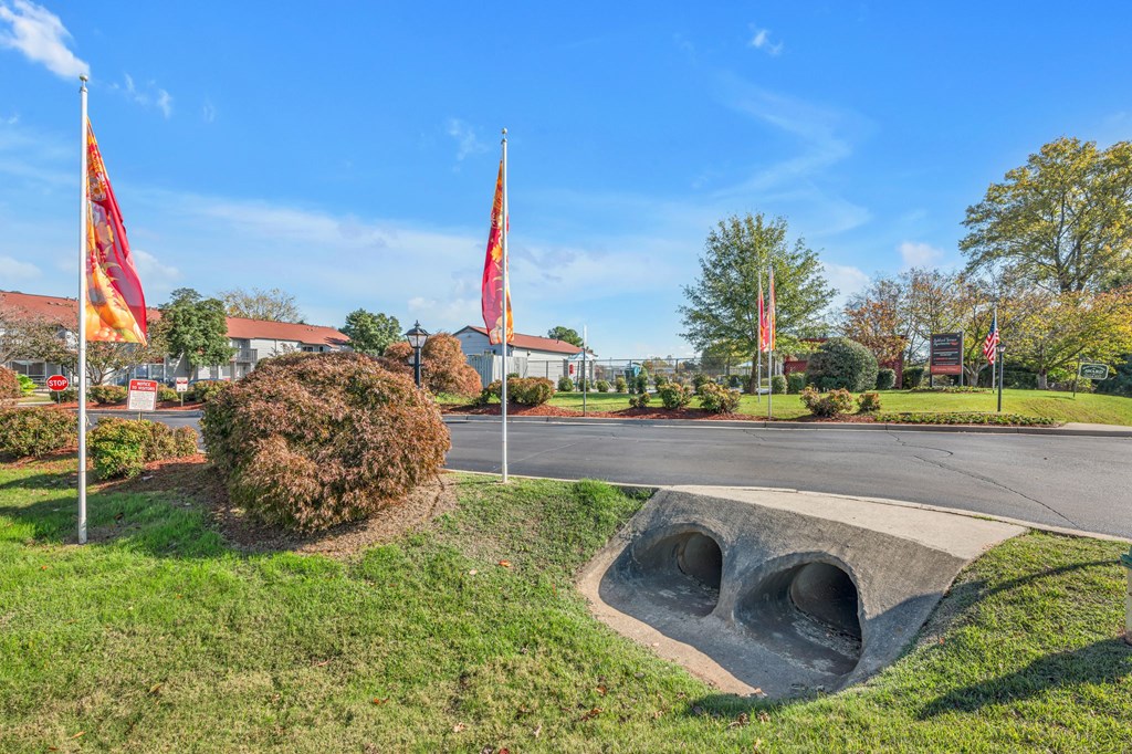 A park with a large concrete structure and flags.
