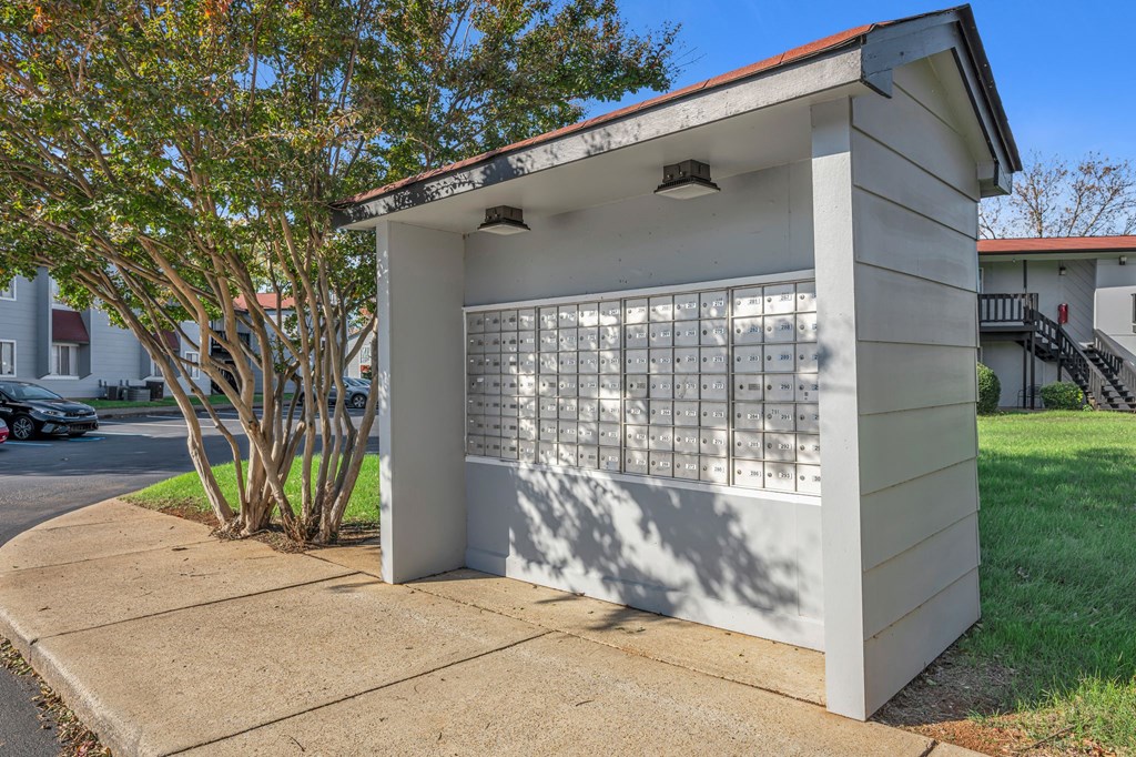A small white building with a red roof and a plaque on the side.