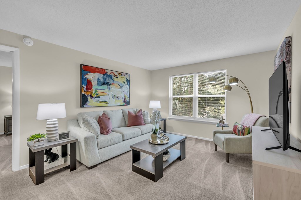 A living room with a couch, two end tables, and a television.