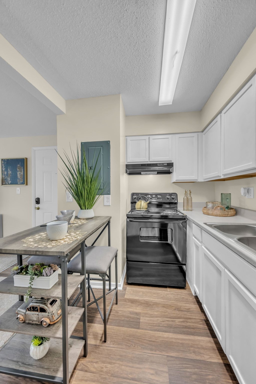 A kitchen with a black oven and white cabinets.