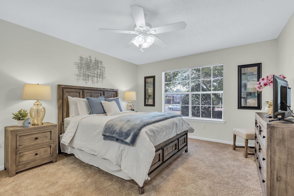 a bedroom with a bed and a ceiling fan