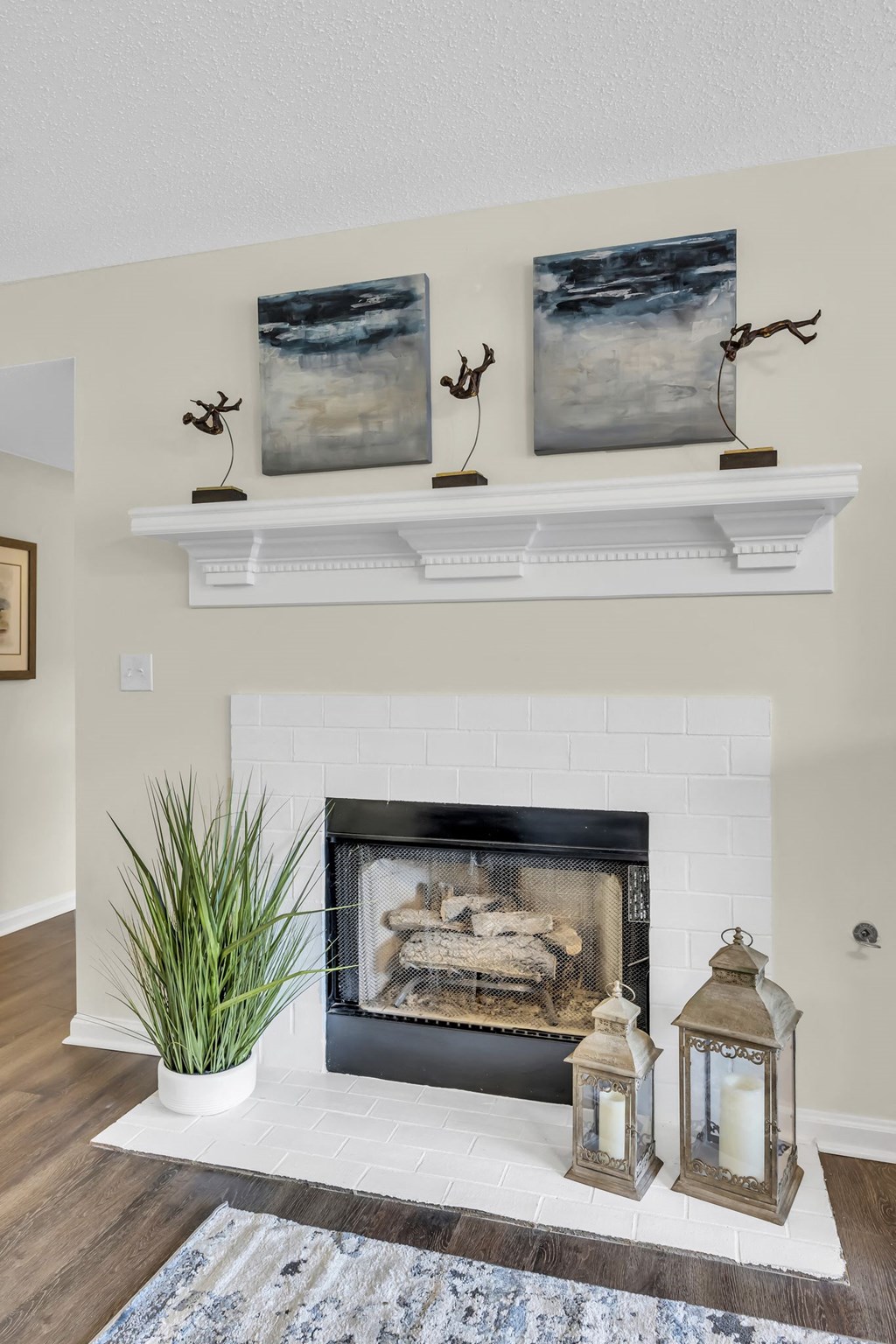 a living room with a fireplace and paintings on the wall