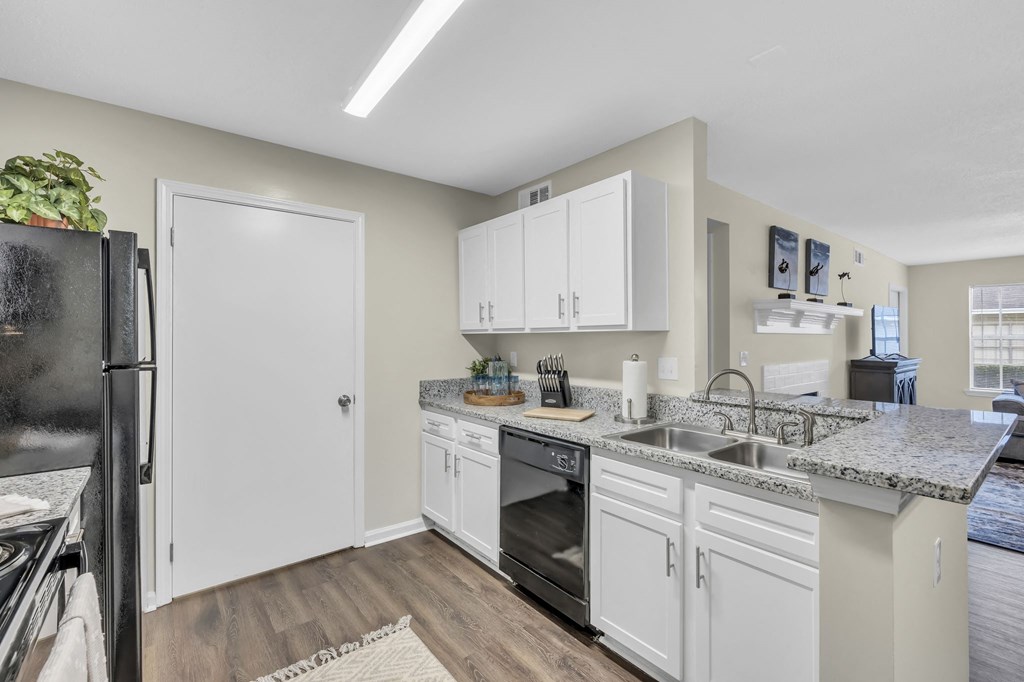 a kitchen with white cabinets and a sink and a refrigerator
