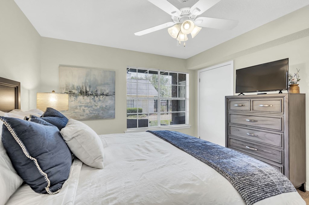 a bedroom with a large bed and a ceiling fan