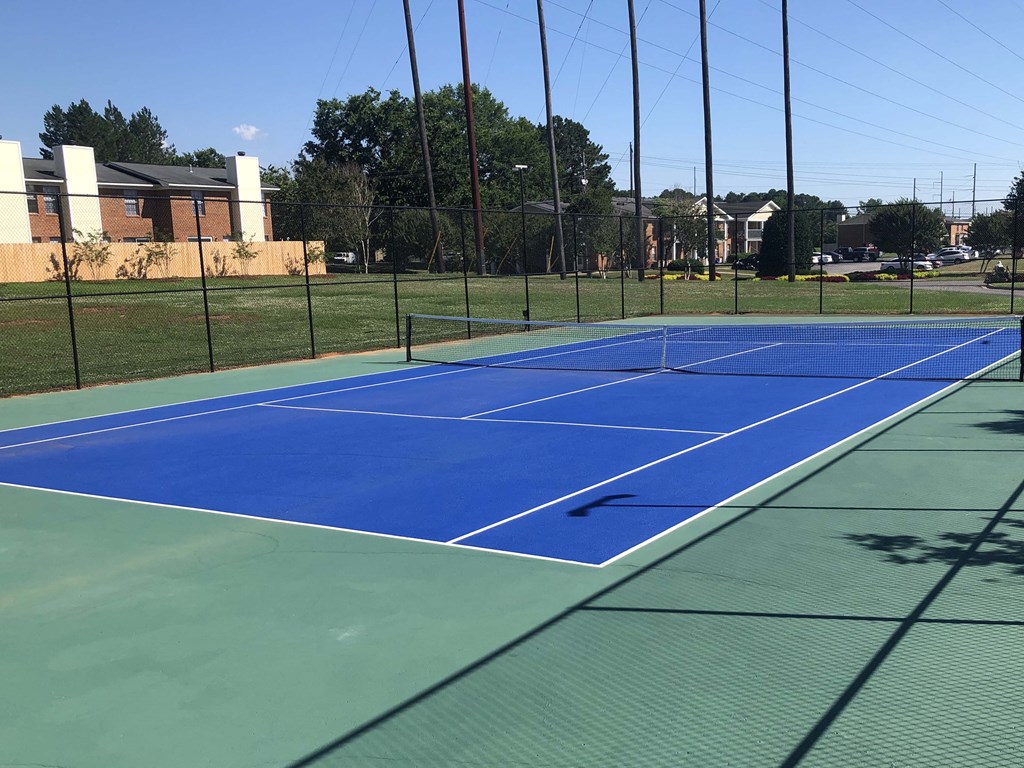 a blue tennis court with a fence around it