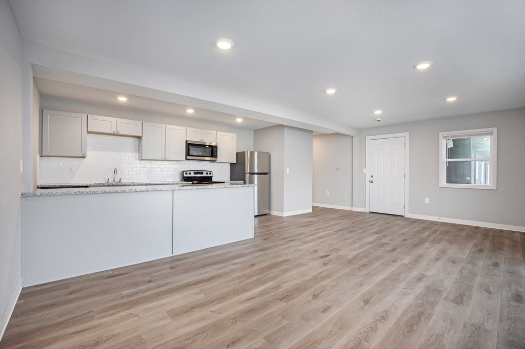 A kitchen with white cabinets and a wooden floor.at Palisades Apartments, Kansas City, MO