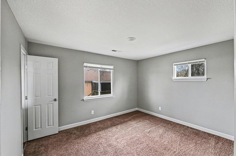 A room with a carpeted floor and a window.